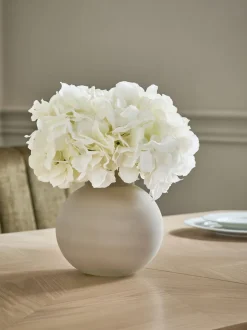 Arrangement met kunsthortensia in grote grijze glazen vaas