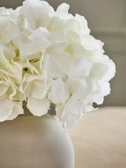 Arrangement met kunsthortensia in grote grijze glazen vaas