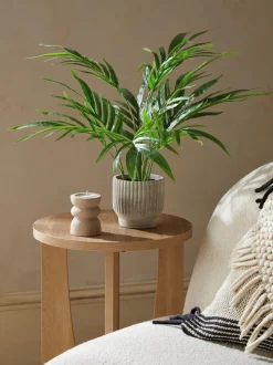 Kleine Kentia-kunstpalmplant in geribbelde betonnen pot