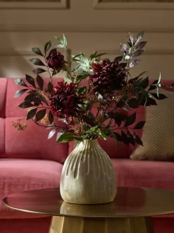 Kunstbloemstuk met donkere bloemen in keramische vaas