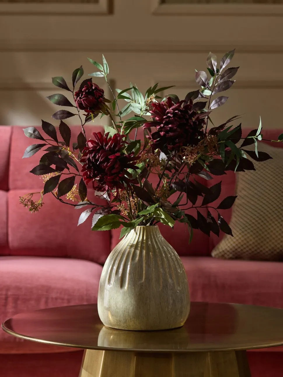Kunstbloemstuk met donkere bloemen in keramische vaas