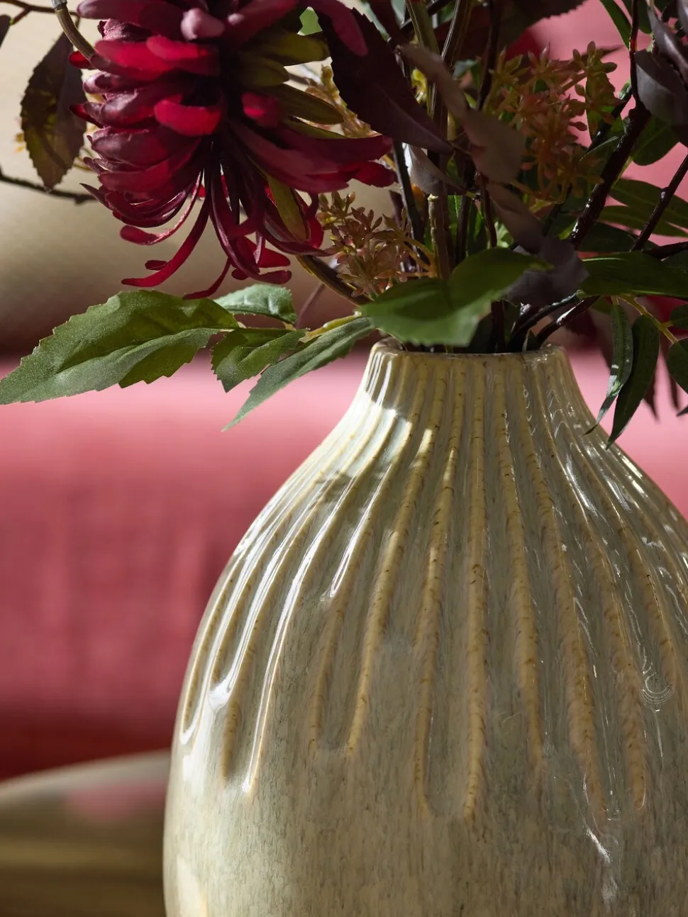 Kunstbloemstuk met donkere bloemen in keramische vaas