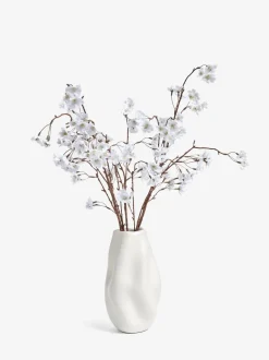 Kunstbloesemstelenarrangement in witte keramische vaas