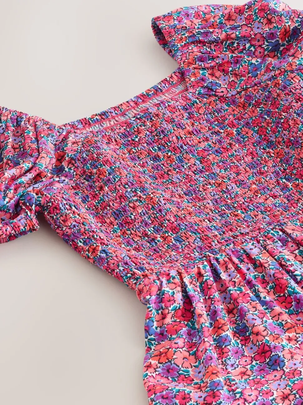 Roze met vrolijke print - Romper met smokwerk (3-16jr)